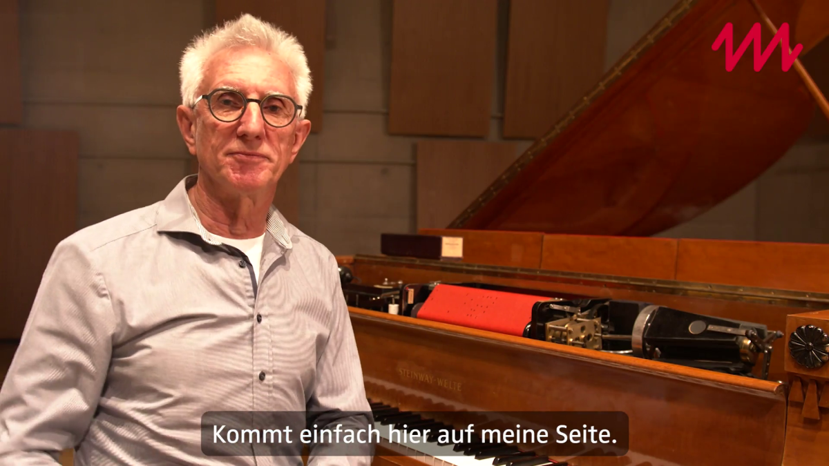 Mitarbeiter sitzt am Flügel Mitarbeiter sitzt am Flügel